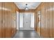 Traditional entryway with wood paneling, gray tile flooring, and a white front door and trim at 2032 Se 12Th St, Ocala, FL 34471