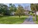 Exterior view of the single-Gathering home, mature trees, and a long driveway at 2032 Se 12Th St, Ocala, FL 34471