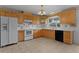 Kitchen featuring tile flooring, white appliances, and light wood cabinets at 2032 Se 12Th St, Ocala, FL 34471