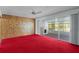 Retro living room features red carpet, wood paneling, and sliders to the lanai at 2032 Se 12Th St, Ocala, FL 34471