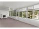 Enclosed sunroom featuring a cozy fireplace, carpeted floors, and lots of natural light at 2032 Se 12Th St, Ocala, FL 34471