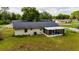 Back of the house with enclosed patio and green lawn at 2140 Ne 40Th St, Ocala, FL 34479