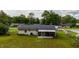 The house has a green yard and an enclosed back porch at 2140 Ne 40Th St, Ocala, FL 34479