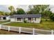 Charming single-story home featuring a well-maintained lawn and a classic white picket fence at 2140 Ne 40Th St, Ocala, FL 34479