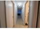 Hallway with neutral colored floors, several closed doors, and view into other rooms of the home at 2140 Ne 40Th St, Ocala, FL 34479