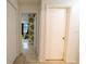 Hallway with open door and view of room with decorative wallpaper, and tile flooring throughout at 2140 Ne 40Th St, Ocala, FL 34479