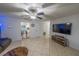 Bright living room featuring tile floors, modern ceiling fan, and large screen TV at 2140 Ne 40Th St, Ocala, FL 34479