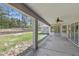Back porch with fan overlooking wooded backyard at 22189 Sw Neptune Blvd, Dunnellon, FL 34431