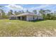 Exterior view of the home showcasing the expansive grassy backyard at 22189 Sw Neptune Blvd, Dunnellon, FL 34431