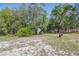 Backyard features a storage shed and a fire pit surrounded by trees at 22189 Sw Neptune Blvd, Dunnellon, FL 34431