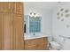 Well-lit bathroom featuring a vanity, a toilet, and a shower with accessible handrails at 22189 Sw Neptune Blvd, Dunnellon, FL 34431