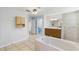 Spacious bathroom featuring a soaking tub, wooden vanity, and tiled floors at 22189 Sw Neptune Blvd, Dunnellon, FL 34431