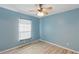 Bedroom with light blue walls, fan, window, and light colored wood-look flooring at 22189 Sw Neptune Blvd, Dunnellon, FL 34431