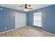 Light blue bedroom featuring double door closet, window and light colored wood-look flooring at 22189 Sw Neptune Blvd, Dunnellon, FL 34431
