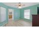 Bright bedroom with wood-look flooring and a view of an en-suite bathroom, illuminated by natural light at 22189 Sw Neptune Blvd, Dunnellon, FL 34431