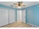 Light blue bedroom featuring double door closet and view to hall with light wood-look flooring at 22189 Sw Neptune Blvd, Dunnellon, FL 34431