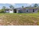 Beautiful one-story home showcasing a manicured front yard, large windows, and lovely curb appeal at 22189 Sw Neptune Blvd, Dunnellon, FL 34431