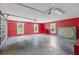 Spacious garage with multiple windows, a bright red wall, and high ceilings at 22189 Sw Neptune Blvd, Dunnellon, FL 34431