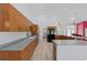 Spacious kitchen featuring wood cabinets, black appliances, and a view of an adjoining living area at 22189 Sw Neptune Blvd, Dunnellon, FL 34431