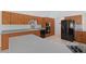 Kitchen showcasing wood cabinets, gray countertops, black appliances, and modern flooring at 22189 Sw Neptune Blvd, Dunnellon, FL 34431