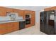Kitchen showcasing wood cabinets, gray countertops, black appliances, and modern flooring at 22189 Sw Neptune Blvd, Dunnellon, FL 34431