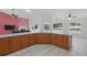 Open layout features kitchen with wood cabinets and island overlooking living room with fireplace at 22189 Sw Neptune Blvd, Dunnellon, FL 34431