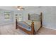 Main bedroom featuring a decorative bed frame, a ceiling fan, wood-look flooring, and views of the outdoors at 22189 Sw Neptune Blvd, Dunnellon, FL 34431