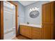 Bathroom featuring a wood vanity, decorative mirror, updated lighting and a tiled walk-in shower at 2576 Ne 34Th St, Ocala, FL 34479