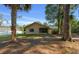 Exterior of home showcasing mature shade trees, screened in porch, and neutral paint at 2576 Ne 34Th St, Ocala, FL 34479
