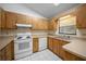 Bright kitchen featuring matching appliances, white tile floors, and wood kitchen cabinets at 2576 Ne 34Th St, Ocala, FL 34479