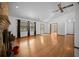 Spacious living room with wood floors, large windows, a ceiling fan, and a cozy brick fireplace at 2576 Ne 34Th St, Ocala, FL 34479