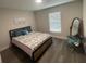 Comfortable bedroom featuring a large window and wood-style floors, offering a serene and inviting atmosphere at 3338 Sw 165Th Loop, Ocala, FL 34473