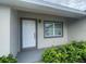 Close-up of the home's entrance featuring a white front door and neat landscaping at 3338 Sw 165Th Loop, Ocala, FL 34473