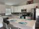 Modern kitchen featuring white cabinets, stainless steel appliances, and a center island with breakfast bar seating at 3338 Sw 165Th Loop, Ocala, FL 34473