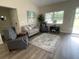 Cozy living room featuring hardwood floors, neutral furniture, and ample natural light at 3338 Sw 165Th Loop, Ocala, FL 34473
