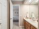 Bathroom with a single sink vanity, mirror, and view into the bedroom at 3815 Ne 17Th Street Cir, Ocala, FL 34470