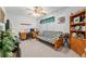 Bright bedroom features a ceiling fan, futon, desk, and decorative shelving at 3815 Ne 17Th Street Cir, Ocala, FL 34470