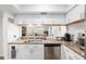 Kitchen features white cabinets, granite counters, stainless steel dishwasher and sink with a bar at 3815 Ne 17Th Street Cir, Ocala, FL 34470