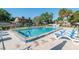 Inviting community pool area with lounge chairs, mature trees, and a nearby condominium complex at 3815 Ne 17Th Street Cir, Ocala, FL 34470