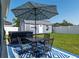 Backyard patio with umbrella-covered table and chairs and hot tub near the shed at 4064 Sw 132Nd Ln, Ocala, FL 34473