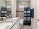 Bathroom with granite countertops, double sinks, a tiled shower/tub combo, and a dark blue shower curtain at 4064 Sw 132Nd Ln, Ocala, FL 34473
