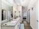 Bathroom with double sink vanity with granite countertops, tiled floors, and views into the walk-in closet and bedroom at 4064 Sw 132Nd Ln, Ocala, FL 34473