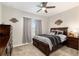 This carpeted bedroom features a ceiling fan and window with grey curtains at 4064 Sw 132Nd Ln, Ocala, FL 34473