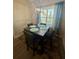 Charming dining area with seating for four beneath a stylish chandelier and large window at 4064 Sw 132Nd Ln, Ocala, FL 34473