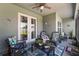 This screened patio has rocking chairs, a ceiling fan, and view of the backyard at 4064 Sw 132Nd Ln, Ocala, FL 34473