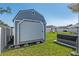 Exterior view of backyard shed with roll-up door and hot tub nearby at 4064 Sw 132Nd Ln, Ocala, FL 34473