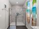 Tiled shower with glass door and decorative accent tile, alongside a tropical-themed shower curtain and window at 4064 Sw 132Nd Ln, Ocala, FL 34473