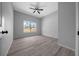 Well-lit bedroom with a ceiling fan, window, light grey walls, and wood-look flooring at 4312 Sw 172Nd Place Rd, Ocala, FL 34473