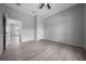 Spacious bedroom with wood-look flooring, light grey walls, a ceiling fan, and an attached bath at 4312 Sw 172Nd Place Rd, Ocala, FL 34473