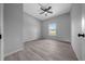 Well-lit bedroom with a ceiling fan, window, light grey walls, and wood-look flooring at 4312 Sw 172Nd Place Rd, Ocala, FL 34473